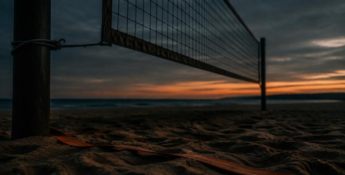 Red de vóley playa al atardecer con cinta naranja sobre la arena